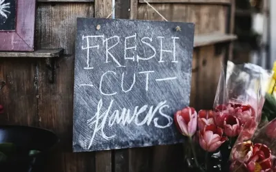 Chalkboard sign outside a small local flower shop